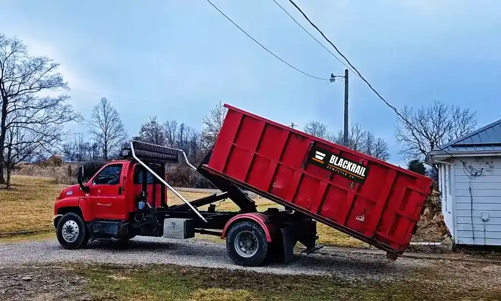 Blackrail Dumpster Co. truck delivering a red roll-off container for a Home & Estate Cleanout Dumpster Lubbock project.