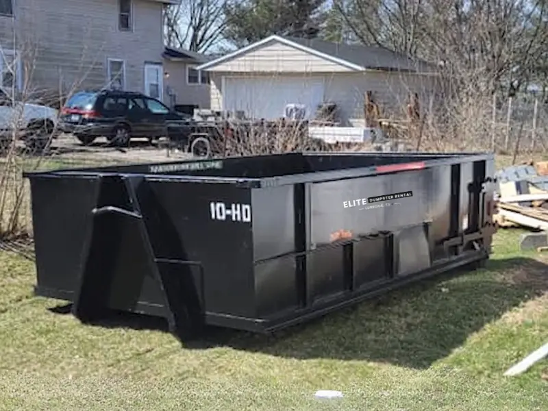 Roll-off dumpster placed beside a landscaped yard during a residential cleanup project